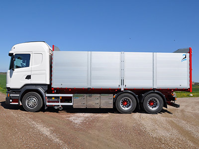 En vit lastbil på en grusväg