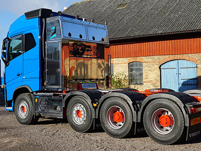 Baksidan av en blå lastbil mot en röd byggnad